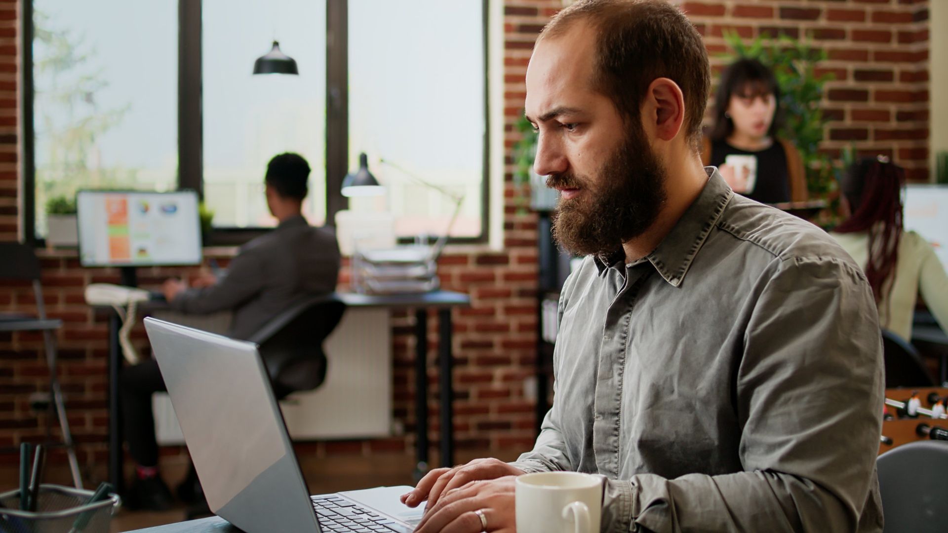 Man working on a laptop in a bright office